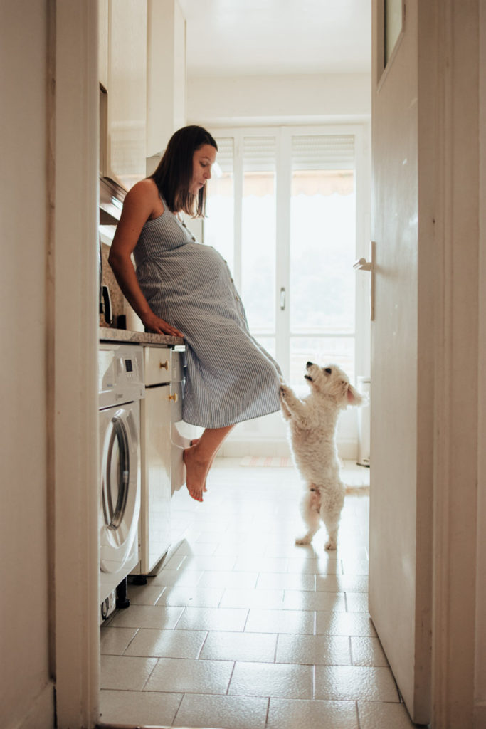 Femme enceinte dans la cuisine avec son chien.
