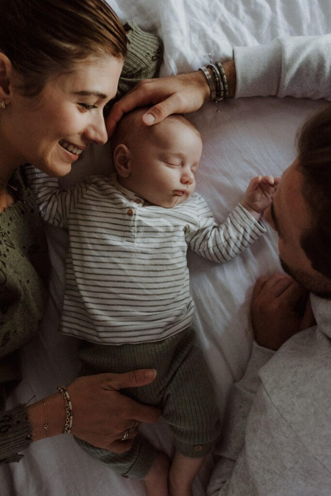 Un nouveau-né sur le lit avec ses parents.